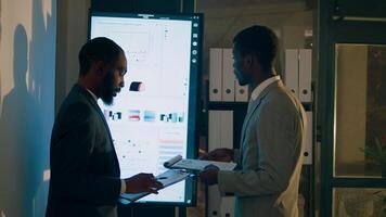 empleados teniendo problema con difícil Tareas a trabajo durante Turno nocturno. compañeros de trabajo en oficina luchando a entender carencia de proyecto progreso, molesto a ven arriba con soluciones foto