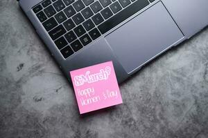 Flat lay photo of laptop with pink postit for international Women's day 8th march. Future is female.