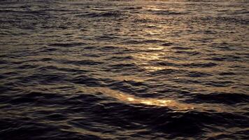 Last glitters on the waves in the sunset when on the move in slow motion video