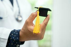 Asian doctor study learn with graduation gap hat in hospital ward, clever bright genius education medicine concept. photo