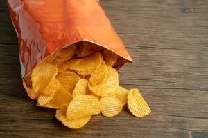 papas fritas, delicioso condimento para barbacoa picante para crips, bocadillo frito de rebanada fina, comida rápida en bolsa abierta. foto