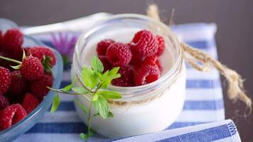 dulce cocido hecho en casa yogur con Fresco frambuesas en un vaso frasco. video
