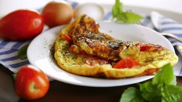 Stuffed omelette with tomatoes on a light wooden background. video