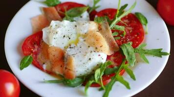 Cooked poached egg with herbs, lightly salted salmon and tomatoes with spices . video