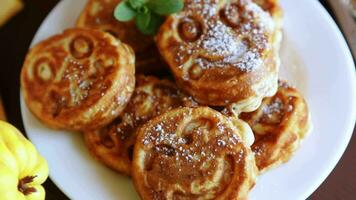 Cooked fried round pancakes with quince filling on a wooden table video