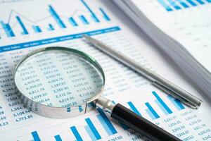 Magnifying glass on graph paper. Financial development, Banking Account, Statistics, Investment Analytic research data economy, Business concept. photo