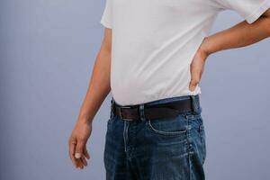 Man wearing white shirt showing back pain photo