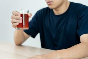 Deprimido joven negocio hombre fanático sensación malo Bebiendo whisky solo a hogar, estresado frustrado solitario Bebiendo alcohol sufre desde problemático espíritu, alcoholismo, vida y familia problemas foto