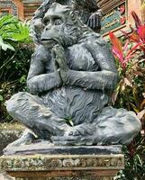 Stone monkeys statues in sacred monkey forest. Old decorative monkey sculptures in Bali ubud sacred forest photo