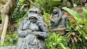 Stone monkeys statues in sacred monkey forest. Old decorative monkey sculptures in Bali ubud sacred forest photo