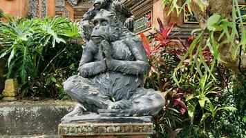 Stone monkeys statues in sacred monkey forest. Old decorative monkey sculptures in Bali ubud sacred forest photo