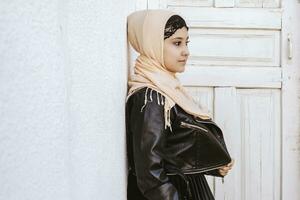 retrato de hermosa Medio este niña en tradicional islámico ropa - hiyab moderno y joven iraní mujer en cuero chaqueta foto