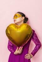 Woman wearing masquerade mask and holding heart shaped air ballon. Valentines Day, Birthday, Anniversary, Festive, Ball celebration concepts photo