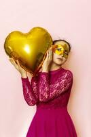 Woman wearing masquerade mask and holding heart shaped air ballon. Valentines Day, Birthday, Anniversary, Festive, Ball celebration concepts photo