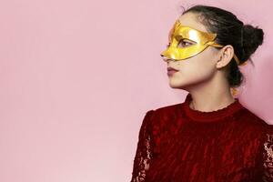 Portrait of beautiful woman in evening dress and golden masquerade mask. Valentines day, Carnival, Festive Ball, Birthday celebration concept. Facial expressions of young female photo