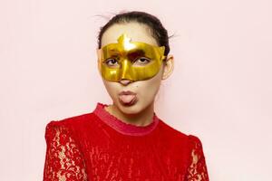 Portrait of beautiful woman in evening dress and golden masquerade mask. Valentines day, Carnival, Festive Ball, Birthday celebration concept. Facial expressions of young female photo