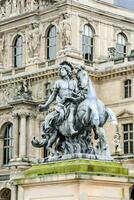 a statue of a man on a horse in front of a building photo