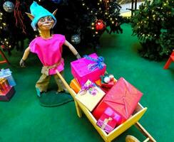 a toy elf is pushing a wheelbarrow with presents photo