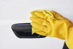 Car disinfecting service. Woman disinfecting car door handle photo