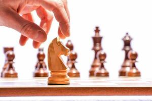 a person is placing a piece on a chess board photo