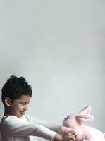 5 years adorable little kid boy playing with plush rabbit bunny toy photo