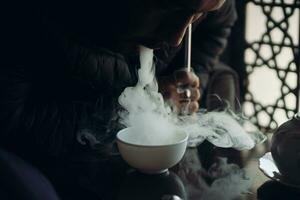 A guy smokes hookah in shisha bar photo