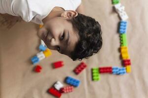 5 years adorable little kid boy playing with plastic brick toys photo