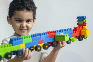 5 5 años adorable pequeño niño chico jugando con el plastico ladrillo juguetes foto