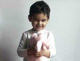 5 years adorable little kid boy playing with plush rabbit bunny toy photo