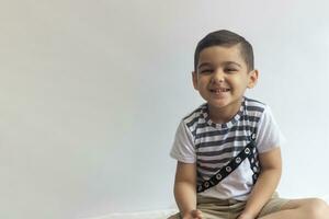 Six years boy portrait. Innocent smiling little boy on grey background. Little boy contorts his face. People, childhood lifestyle concept. photo