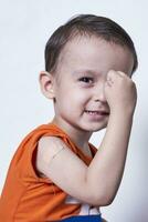 retrato de contento sano pequeño niño demostración vendaje yeso en brazo hombro después consiguiendo vacunación foto