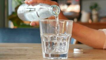 Wasser Gießen von Flasche im ein Glas auf Tabelle video
