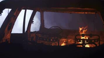 Cinematic film shot of a car burning in flames in the fog at a dark night in slow motion. video