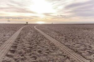 a beach with tracks in the sand photo