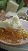 butter cream and honey in a bowl on table . video