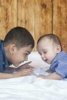 Happy childhood concept. Happy brothers portrait. 6 years and 6 months old boys having fun. Two little kids smiling having good time. Cute little brothers lying and playing together photo