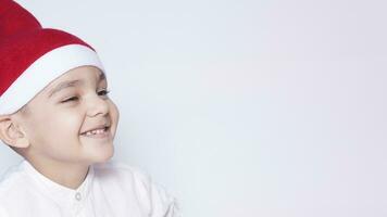 Happy little christmas boy. Celebrating Christmas. 6-7 year old kid with Santa hat. photo