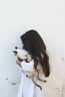 Adorable schoolgirl hugging her lovely kitten photo