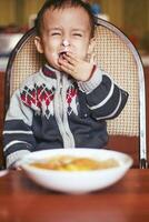 llorando bebé chico. enojado pequeño niño en el cocina foto