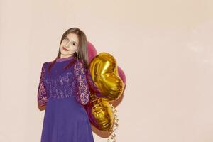 woman holds heart shaped golden air balloons. valentines day, birthday, womens day, anniversary, holiday celebration concept photo