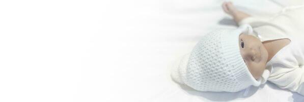 Newborn Baby Boy in Knit Hat Peacefully Lying on white photo