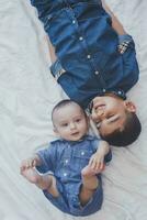 Happy childhood concept. Happy brothers portrait. 6 years boy and 6 months old baby boy having fun. Two little kids smiling to the camera. Cute little brothers lying on bed together photo