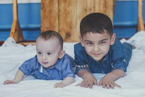 contento infancia concepto. contento hermanos retrato. 6 6 años y 6 6 meses antiguo Niños teniendo divertida. dos pequeño niños sonriente teniendo bueno tiempo. linda pequeño hermanos acostado y jugando juntos foto