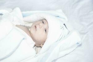 adorable linda recién nacido bebé chico en blanco antecedentes. el encantador niño vistió un Conejo disfraz con largo orejas. día festivo, Pascua de Resurrección. foto