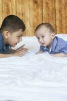 contento infancia concepto. contento hermanos retrato. 6 6 años y 6 6 meses antiguo Niños teniendo divertida. dos pequeño niños sonriente teniendo bueno tiempo. linda pequeño hermanos acostado y jugando juntos foto