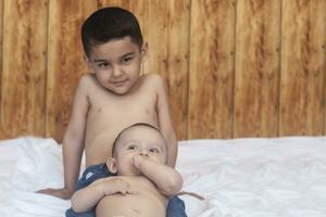 contento infancia concepto. contento hermanos retrato. 6 6 años y 6 6 meses antiguo Niños teniendo divertida. dos pequeño niños sonriente teniendo bueno tiempo. linda pequeño hermanos acostado y jugando juntos foto