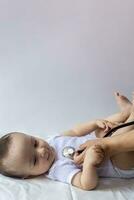 el físico chequeo. del bebe chequeo. el pediatra examinando pequeño chico con un estetoscopio. médico examinando el 6 meses antiguo bebé chico. foto