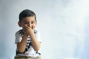 Six years boy portrait. Innocent smiling little boy on grey background. Little boy contorts his face. People, childhood lifestyle concept. photo