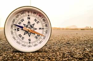 a compass is sitting on the ground in the middle of a road photo