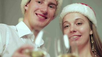 Beautiful couple at Christmas with glasses of champagne looking at camera video